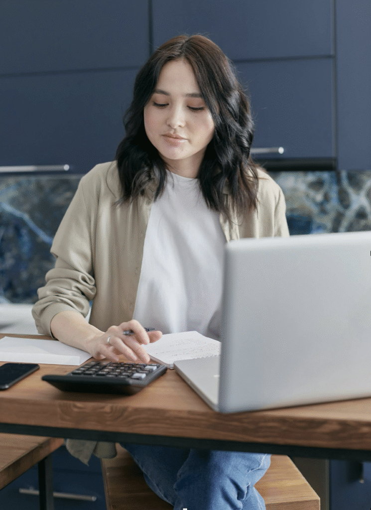 Image via Pexels, woman sits with calculator